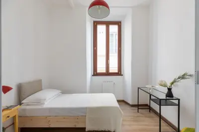 a bedroom with a bed and a desk and a window at iFlat Bright Brand New 3-Bedroom Apt in Monti in Rome