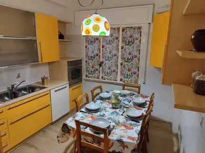 a kitchen with a table with chairs and a sink at A&B Vatican Domus in Rome