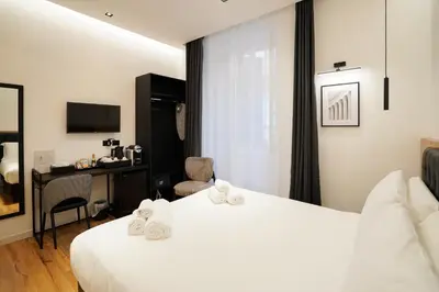 a hotel room with two beds and a desk at No Man's Land Guesthouse in Rome