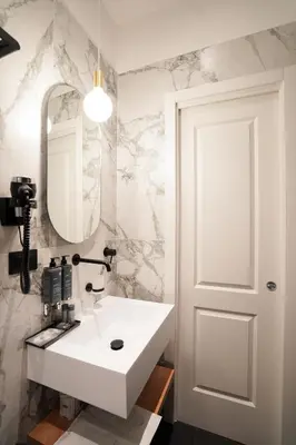 a bathroom with a white sink and a mirror at No Man's Land Guesthouse in Rome