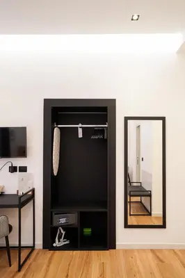 a mirror in the corner of a room with a chair at No Man's Land Guesthouse in Rome