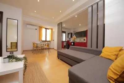 a living room with a couch and a kitchen at Cozy and comfy apartment in Piramide metro stop in Rome
