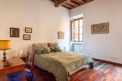 a bedroom with a bed and a desk and a window at Trastevere Lungaretta apartment in Rome
