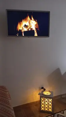 a fire in a fireplace with a tv on a wall at Monteverde Rhome in Rome