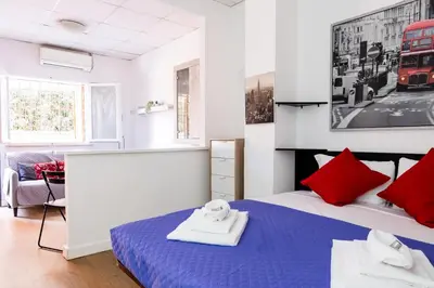 a bedroom with a blue bed with red pillows at Montagnola Mini House in Rome