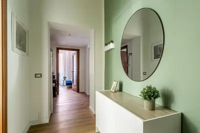 a hallway with a mirror on a green wall at iFlat Colosseum's Brand New & Cozy Nest in Rome