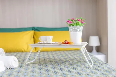 a table with a vase of flowers on top of a bed at Amora Apartments in Rome