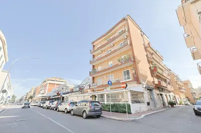 a street with cars parked in front of a building at Amora Apartments in Rome