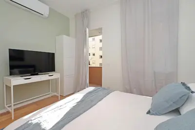 a white bedroom with a bed and a television at Modern Family Apartment in Rome