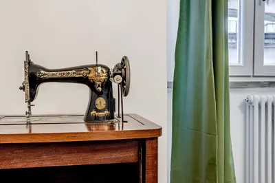 a sewing machine sitting on a table next to a window at La Casa Viola in Rome