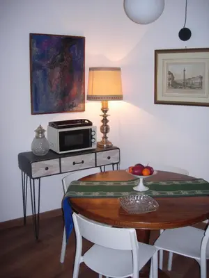 a room with a table with a microwave and a table with chairs at Epic Home in Rome