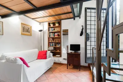 a living room with a white couch and a tv at Trastevere Cottage in Rome