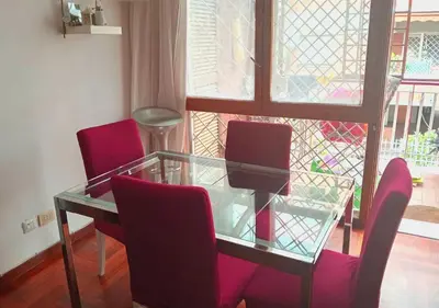 a glass table with three red chairs and a glass table at La casa Bomboniera in Rome