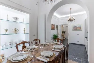 a dining room with a table and chairs and a chandelier at Vista su Campo de Fiori in Rome