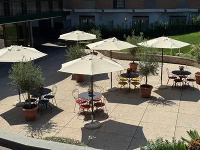 an outdoor patio with tables and chairs with umbrellas at Adoro Hotel in Rome