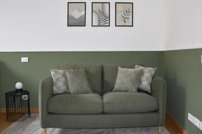 a green couch in a living room with pictures on the wall at RoMa Apt In Vatican in Rome