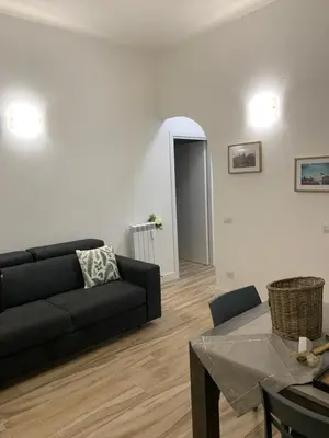 a living room with a black couch and a table at Casa di Azzurra in Rome