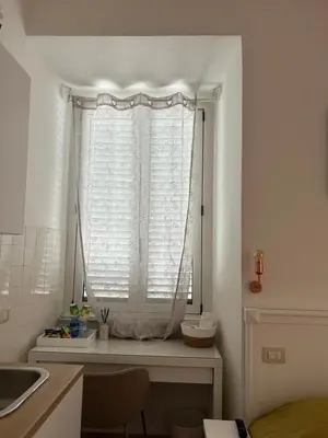 a kitchen with a window with a white curtain at Don sweet home- Hedi 101 in Rome