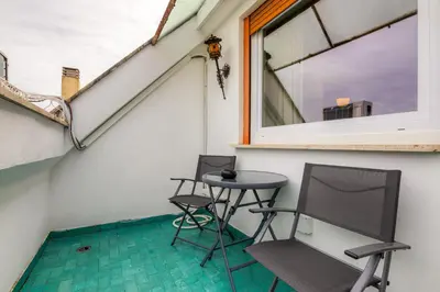 two chairs and a table on a balcony with a window at Elegante appartamento 130mq in stile classico in Rome