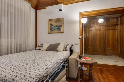 a small bedroom with a bed and a table at Elegante appartamento 130mq in stile classico in Rome