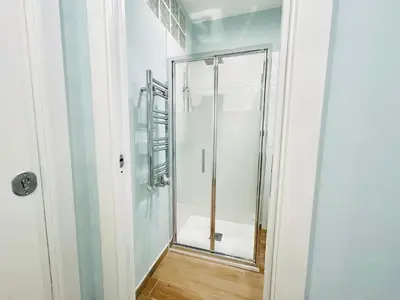a bathroom with a shower with a glass door at The Rooms of Wonders in Rome