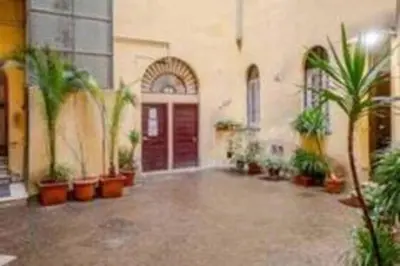 a large courtyard with potted plants in a building at Charme Holidays Trastevere in Rome