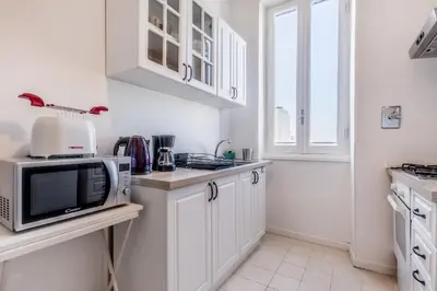 a kitchen with white cabinets and a microwave at Galaxia Home in Rome