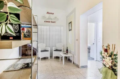 a living room with white walls and a table and chairs at Galaxia Home in Rome