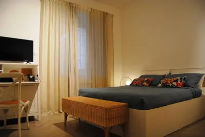 a bedroom with a bed with a television and a chair at Alloggio Appio Claudio con Corte Esclusiva I Metro A in Rome