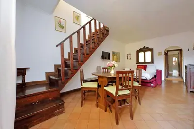 a living room with a wooden table and a staircase at St.Margherita Charming House in Rome