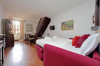 a bedroom with a large bed and a red couch at St.Margherita Charming House in Rome