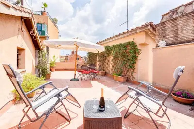a patio with a table and chairs and an umbrella at Romantic house with terrace in Rome