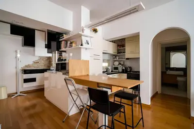 a kitchen with a wooden table and chairs at 5 Min From Trastevere Rome Chic Apartment in Rome