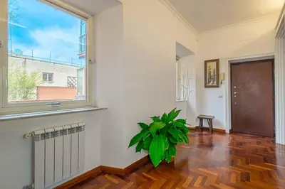 a living room with a large window and a plant at ht m&n bilo colosseo in Rome