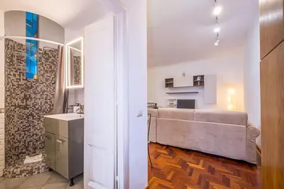 a living room with a large couch and a kitchen at ht m&n bilo colosseo in Rome