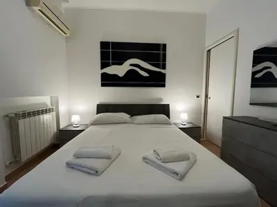 a bedroom with a large white bed with two towels at La Dolce Vita - Casa Mì in Rome