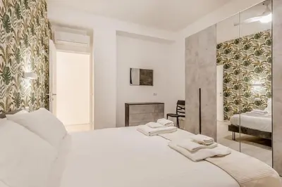 a white bedroom with a large bed and a fireplace at Casa Vaticano di Simone&Alessio in Rome