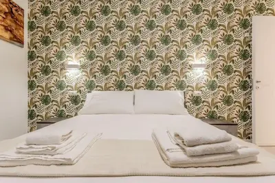 a bedroom with a white bed with a wall at Casa Vaticano di Simone&Alessio in Rome