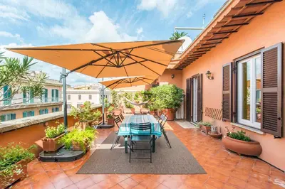 a patio with a table and an umbrella at Casa di Alice in Rome