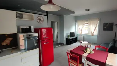 a kitchen with a red refrigerator next to a table at Nuova Casa Elena a Montesacro in Rome