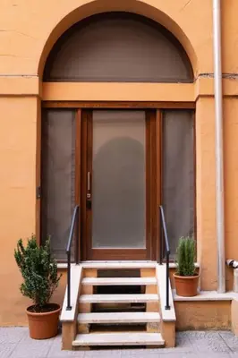 a staircase leading to a door with two potted plants at NEW Mini Loft per 3 a Roma centro in Rome