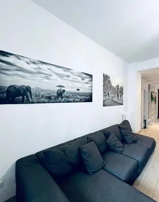 a living room with a blue couch against a white wall at home sweet home san pietro in Rome