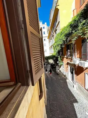 a person walking down a street between two buildings at Colosseum Apartment - Your Cozy Roman Escape in Rome