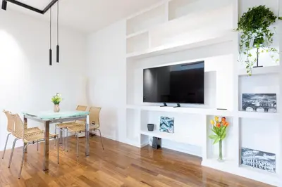 a dining room with a table and a tv on a wall at Una Terrazza su San Pietro in Rome