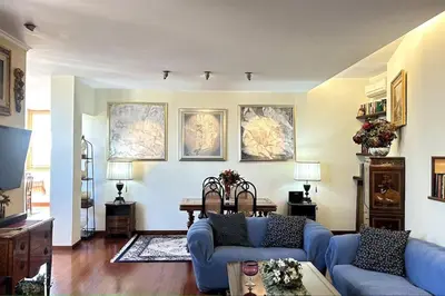 a living room with blue couches and paintings on the wall at Penthouse with terrace - Vatican Museums, Saint Peter's in Rome