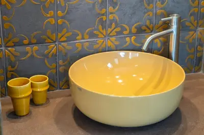 a bowl sink sitting on a counter with two yellow boots at Della Vittoria Penthouse in Rome