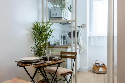 a dining room with a table and a kitchen at La Maison du Charme in Rome