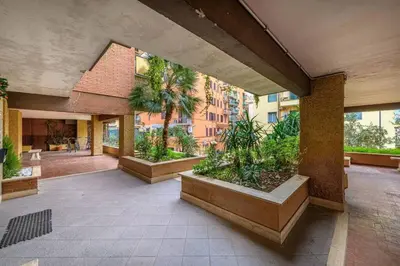 a courtyard with palm trees and plants in a building at Delizioso Monolocale con vista in Rome