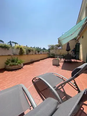a patio with chairs and tables on a brick patio at Terrazza Flaminia in Rome