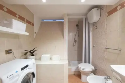 a bathroom with a washing machine and a toilet at Elegant loft at Piazza Vittorio in Rome